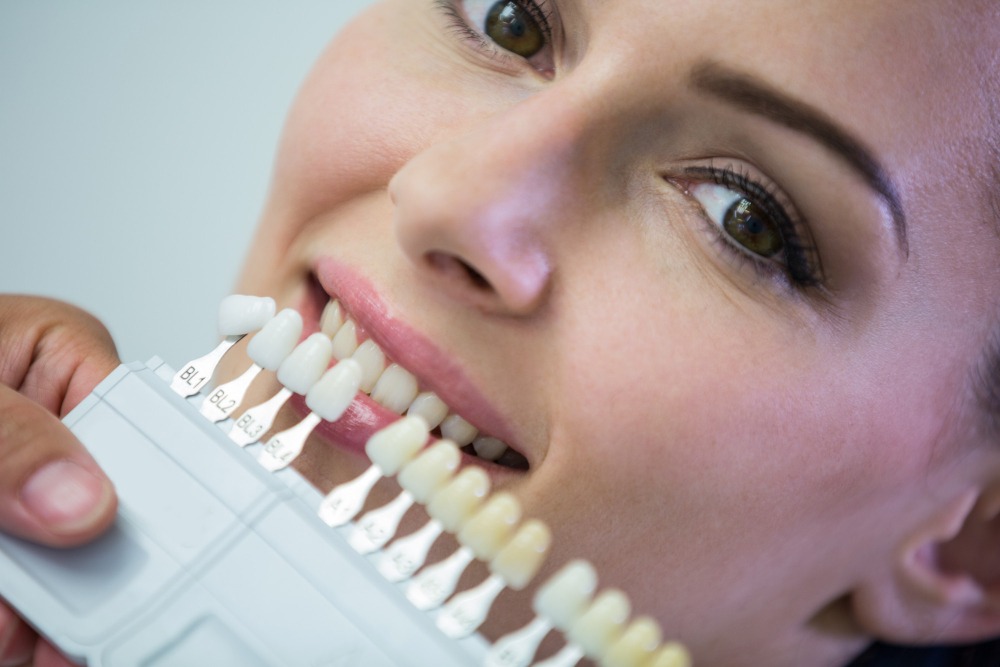 Zirconium-dentist-examining-female-patient-with-teeth-shades